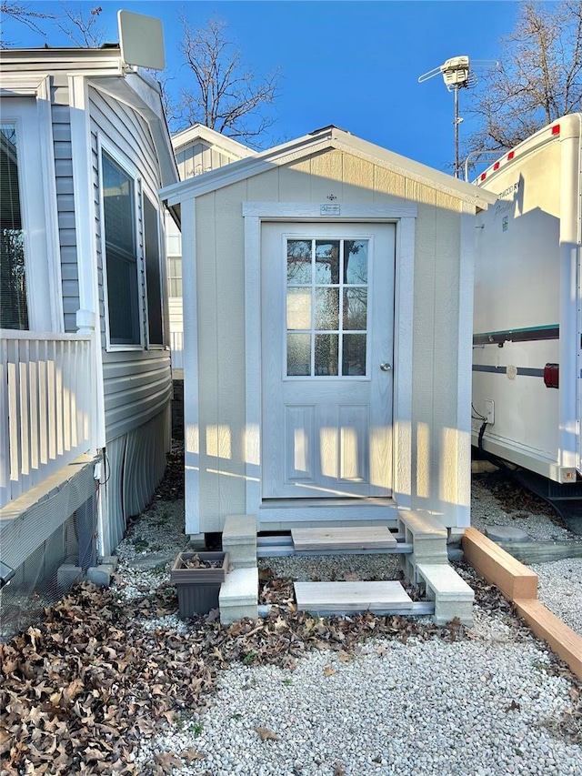 view of side of property featuring a storage shed, an outdoor structure, and entry steps
