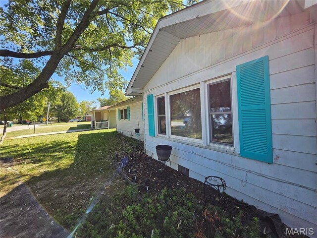view of side of home with a lawn