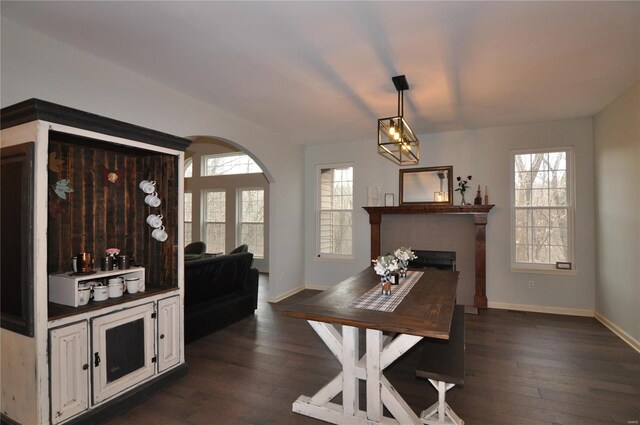 4072 Osage Rdg, House Springs, MO 63051 - dining area featuring baseboards, a fireplace, arched walkways, and dark wood-type flooring