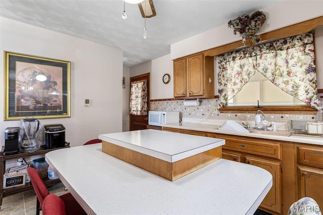 113 S Madison St, Desloge, MO 63601 - kitchen featuring white microwave, a kitchen island, light countertops, and tasteful backsplash