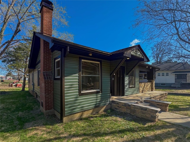 view of property exterior featuring a chimney and a yard