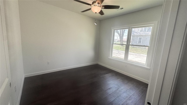unfurnished room with baseboards, dark wood finished floors, and a ceiling fan