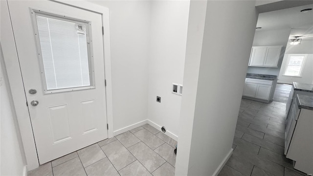 laundry area featuring washer hookup, hookup for an electric dryer, light tile patterned floors, and baseboards