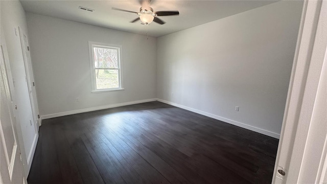 unfurnished room with dark wood-style flooring, a ceiling fan, and baseboards