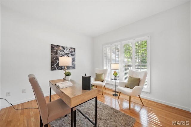 home office with baseboards and light wood-type flooring