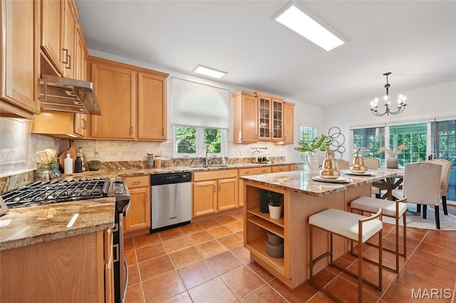 kitchen featuring stainless steel appliances, a sink, a kitchen breakfast bar, and light tile patterned floors
