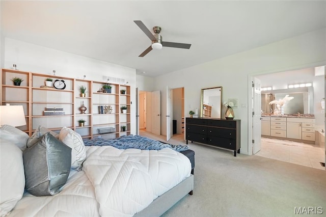 bedroom with light colored carpet, ensuite bath, and ceiling fan