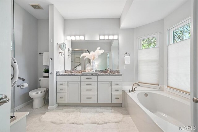 bathroom with toilet, a garden tub, vanity, a stall shower, and tile patterned floors