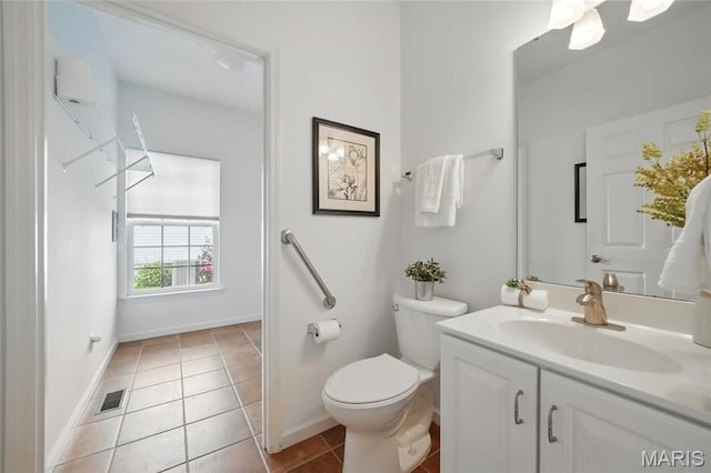 bathroom with toilet, tile patterned floors, baseboards, and vanity