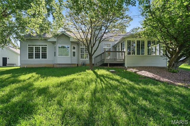 rear view of house with a lawn and a wooden deck