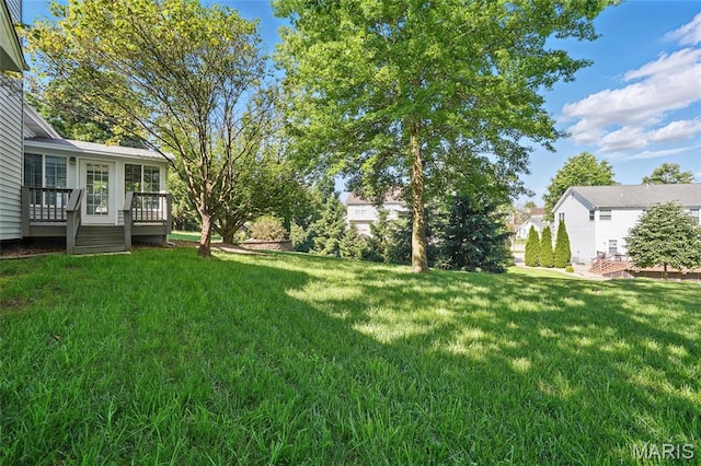 view of green lawn featuring a deck