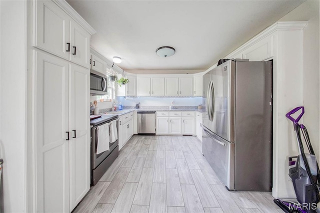 24478 Trolley Ln, Saint Robert, MO 65584 - kitchen with appliances with stainless steel finishes, white cabinets, light wood-style flooring, and a sink
