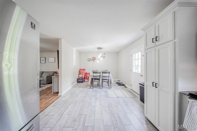 24478 Trolley Ln, Saint Robert, MO 65584 - entryway with light wood-type flooring, a chandelier, and baseboards