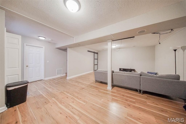 24478 Trolley Ln, Saint Robert, MO 65584 - finished basement with light wood-style floors, a textured ceiling, and baseboards