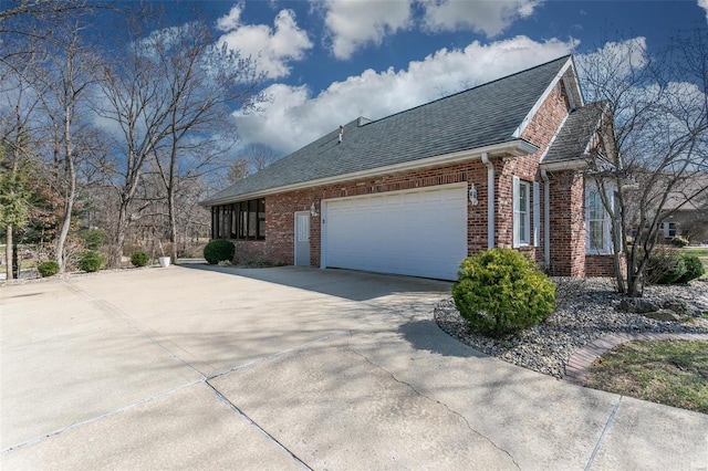 view of property exterior featuring driveway, brick siding, a garage, and a shingled roof