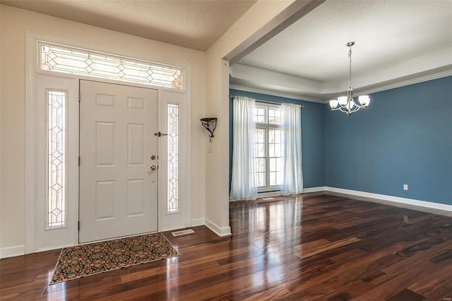 foyer with a chandelier, wood finished floors, and baseboards