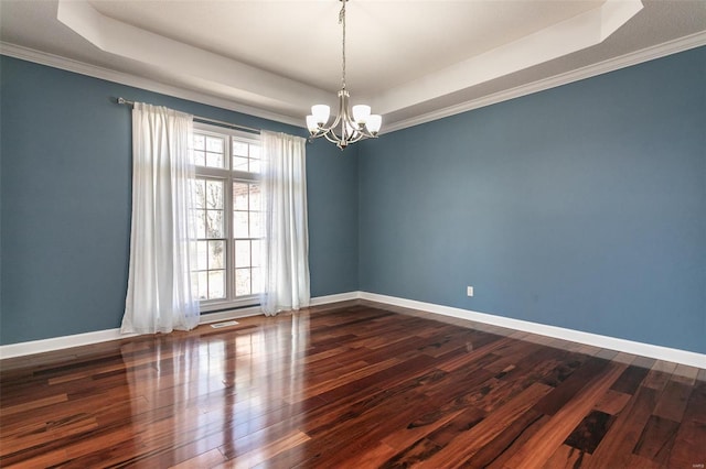 empty room featuring a tray ceiling, a chandelier, dark wood-style flooring, baseboards, and ornamental molding