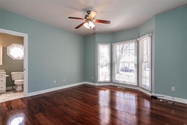 unfurnished bedroom featuring multiple windows, hardwood / wood-style flooring, and baseboards