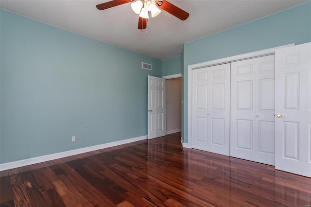 unfurnished bedroom featuring wood finished floors, a closet, baseboards, and ceiling fan
