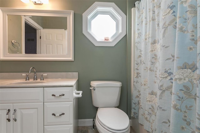 bathroom with baseboards, toilet, vanity, and curtained shower