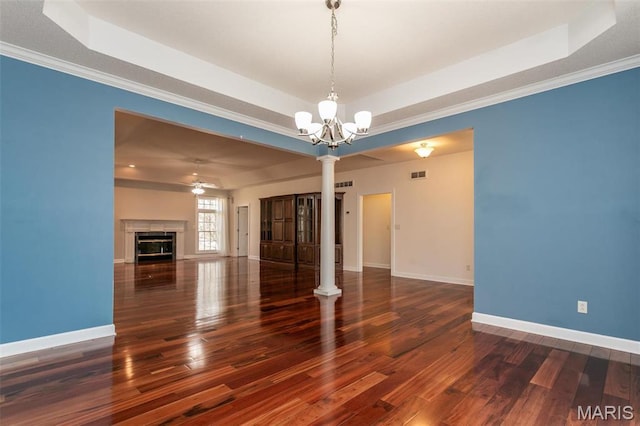 10 Dunbridge Ct, Glen Carbon, IL 62034 - unfurnished living room featuring a raised ceiling, ornate columns, wood finished floors, a chandelier, and a ceiling fan