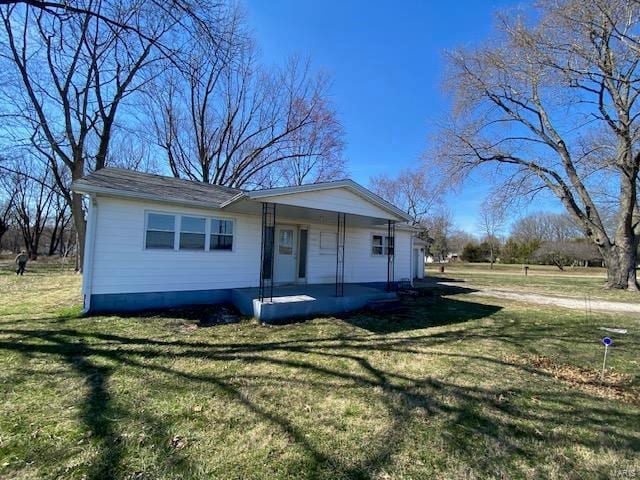 ranch-style home with covered porch and a front lawn