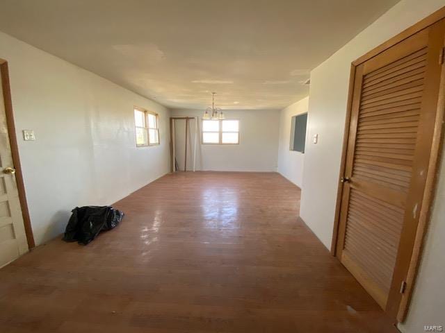 unfurnished room with a chandelier and wood finished floors