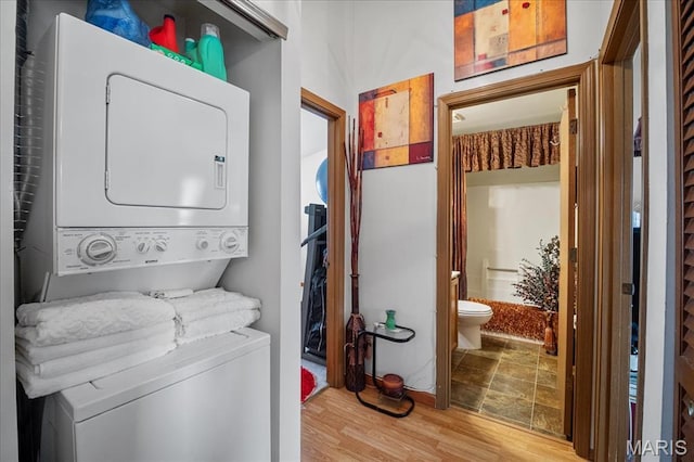 4304 Inlet Isle Dr, Florissant, MO 63034 - clothes washing area featuring stacked washer / dryer and wood finished floors