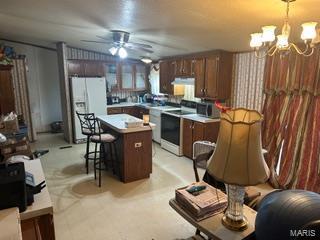 19050 Sikes Rd, Saint Genevieve, MO 63670 - kitchen featuring white fridge with ice dispenser, range with electric stovetop, a chandelier, ceiling fan, and a kitchen island