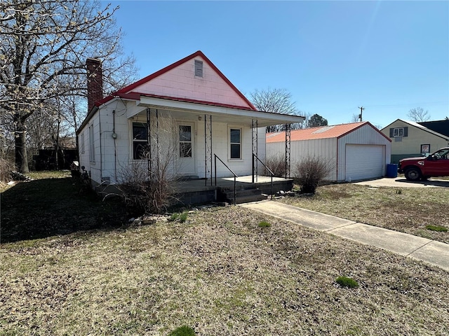 104 Selma St, Sikeston, MO 63801 - view of front facade featuring a chimney, covered porch, an outbuilding, a garage, and concrete driveway