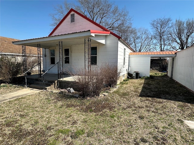 104 Selma St, Sikeston, MO 63801 - view of front facade featuring covered porch, central air condition unit, and metal roof