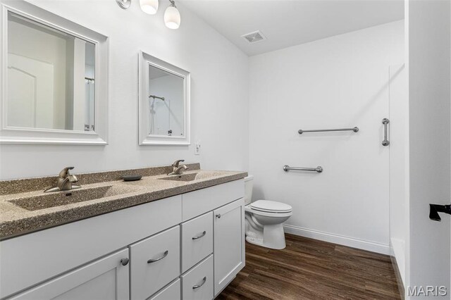 533 Windsor Ln, Farmington, MO 63640 - bathroom with double vanity, toilet, wood finished floors, and baseboards