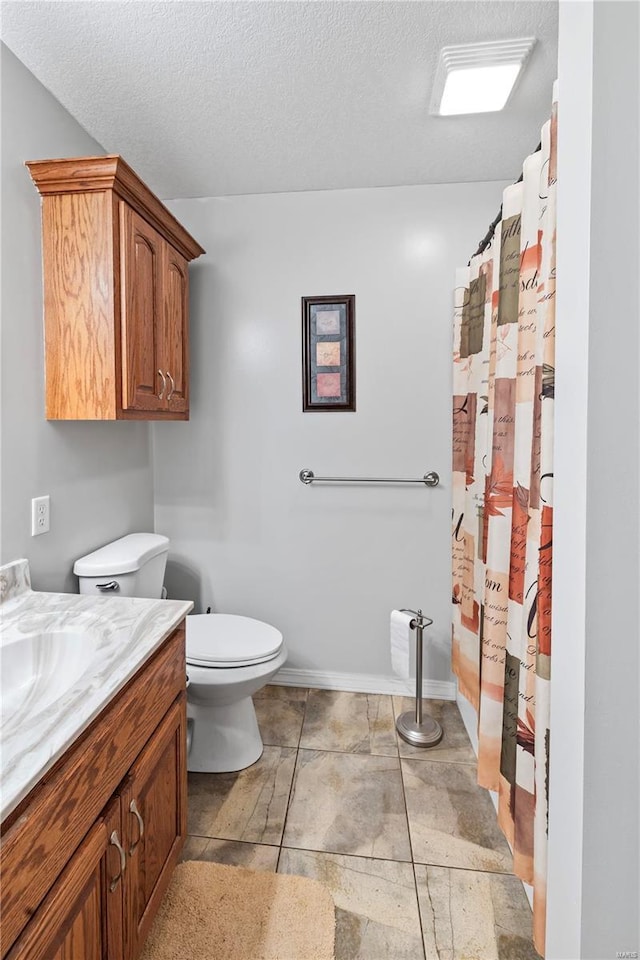full bathroom with toilet, vanity, a textured ceiling, and curtained shower