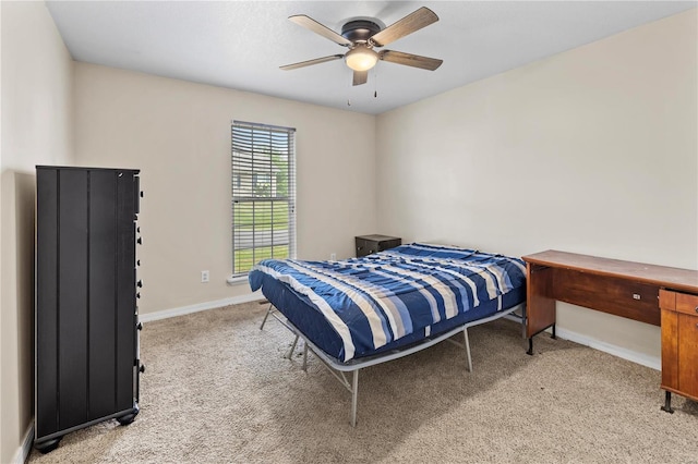 bedroom featuring light carpet, baseboards, and ceiling fan
