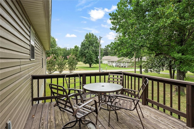 deck featuring a lawn and outdoor dining area