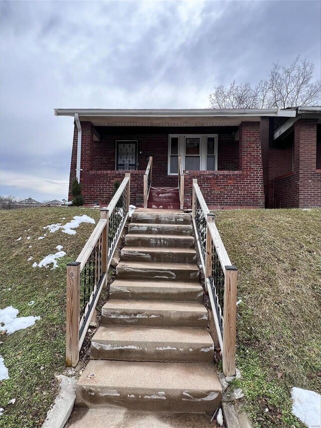 5276 Genevieve Ave, Saint Louis, MO 63120 - view of front of property featuring brick siding, covered porch, and stairway