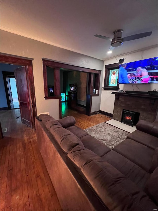 5276 Genevieve Ave, Saint Louis, MO 63120 - home theater featuring a ceiling fan, wood-type flooring, baseboards, and a warm lit fireplace