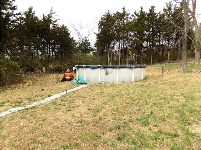 view of green lawn featuring a covered pool