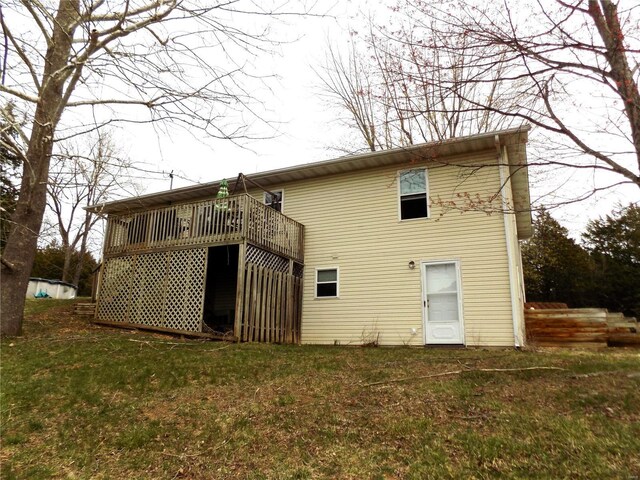 rear view of property with a deck and a lawn