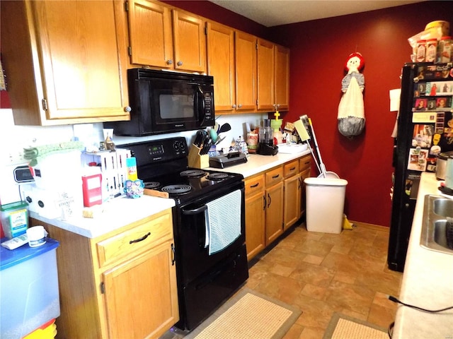kitchen with black appliances, light countertops, and a sink
