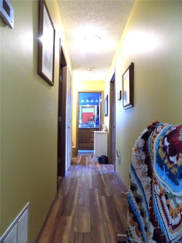 hall featuring a textured ceiling and wood-type flooring