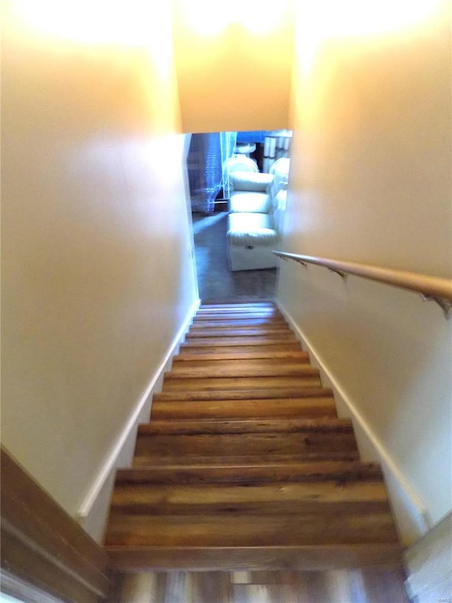 stairway featuring wood finished floors and baseboards