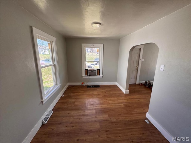 427 S Louisiana St, Cape Girardeau, MO 63703 - unfurnished dining area featuring wood finished floors, baseboards, arched walkways, and cooling unit