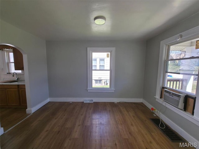 427 S Louisiana St, Cape Girardeau, MO 63703 - unfurnished dining area featuring arched walkways, dark wood-type flooring, and healthy amount of natural light