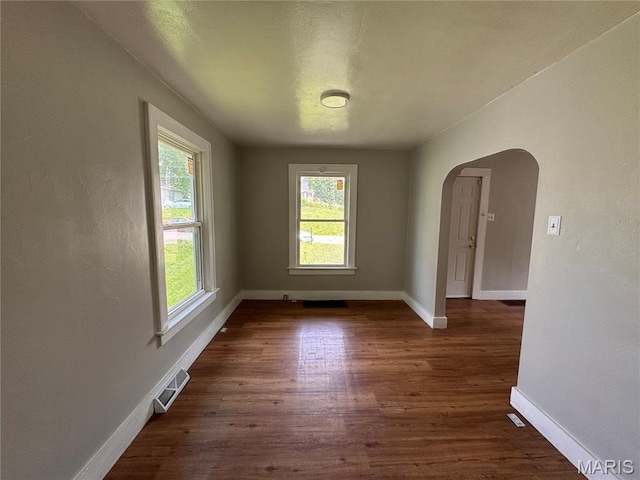427 S Louisiana St, Cape Girardeau, MO 63703 - spare room featuring arched walkways, dark wood-style flooring, and baseboards