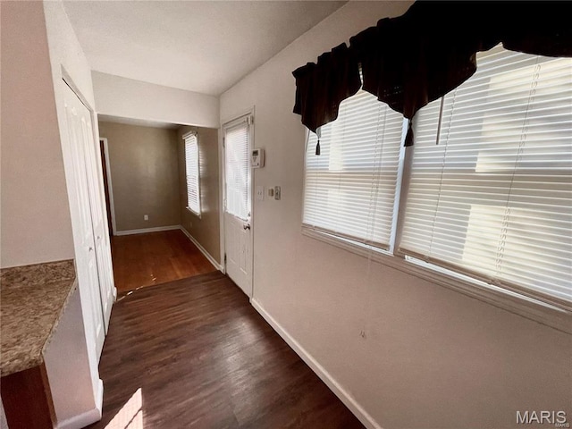doorway with wood finished floors and baseboards