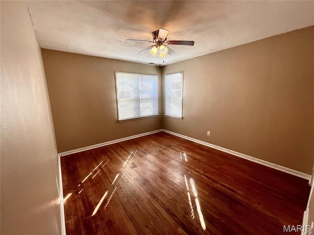 unfurnished room featuring wood finished floors, ceiling fan, and baseboards