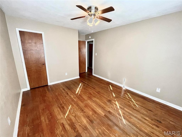 unfurnished bedroom featuring baseboards, wood finished floors, and a ceiling fan
