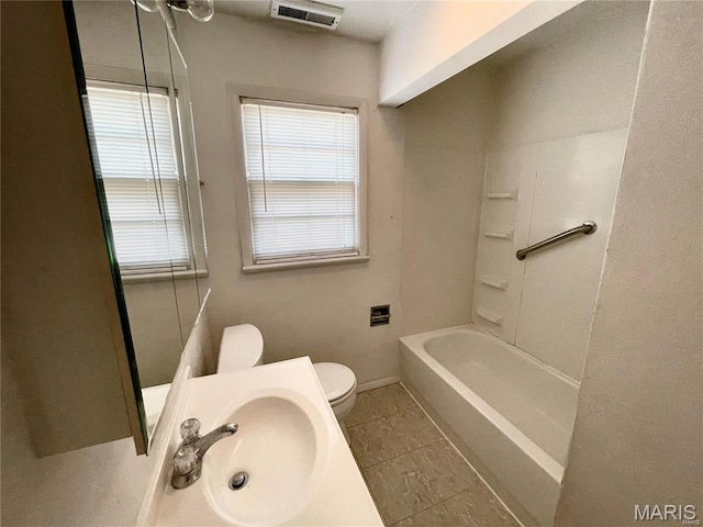 bathroom featuring a sink, toilet, baseboards, and tile patterned flooring