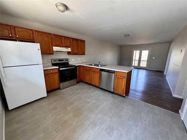 kitchen with appliances with stainless steel finishes, under cabinet range hood, a sink, a peninsula, and light countertops